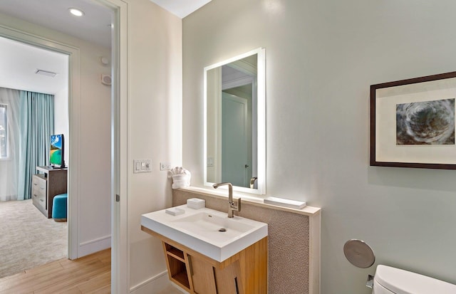 bathroom featuring hardwood / wood-style flooring, vanity, and toilet