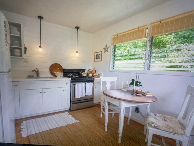 kitchen with stainless steel electric range, white refrigerator, white cabinets, hanging light fixtures, and sink