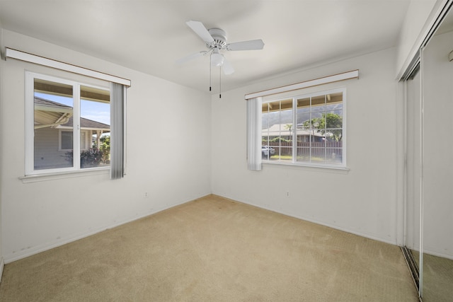 unfurnished bedroom featuring a closet, light carpet, and ceiling fan