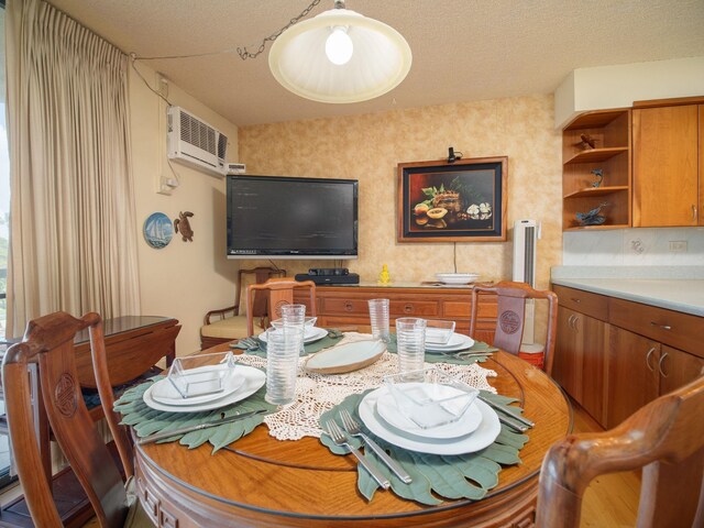 dining space with a textured ceiling and a wall mounted AC