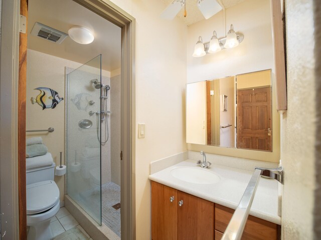 bathroom featuring vanity, walk in shower, toilet, tile patterned floors, and ceiling fan