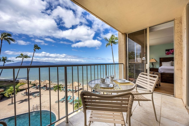 balcony featuring a water view and a view of the beach