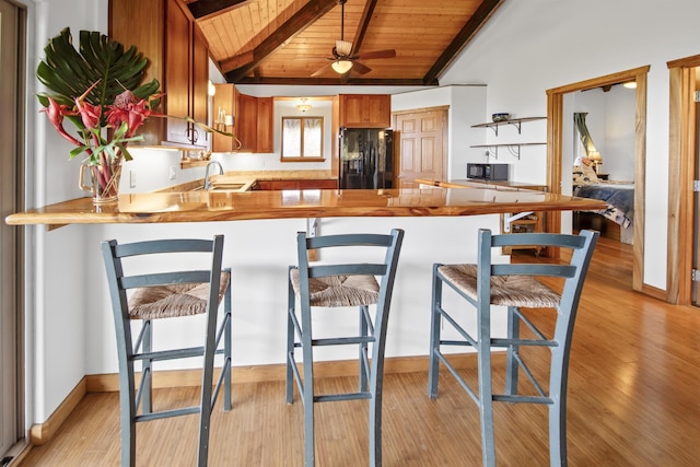 kitchen featuring kitchen peninsula, wood ceiling, ceiling fan, black appliances, and light hardwood / wood-style flooring