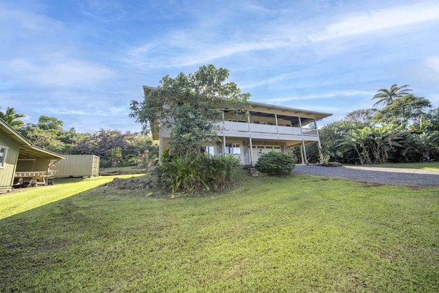 view of front of home with a balcony and a front lawn