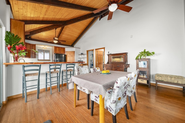 dining area featuring beam ceiling, high vaulted ceiling, light hardwood / wood-style flooring, and wood ceiling