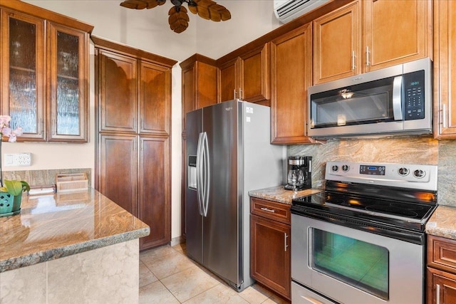 kitchen featuring stainless steel appliances, light stone countertops, and tasteful backsplash