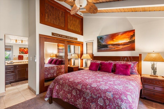 tiled bedroom featuring ensuite bathroom, sink, wood ceiling, ceiling fan, and beamed ceiling