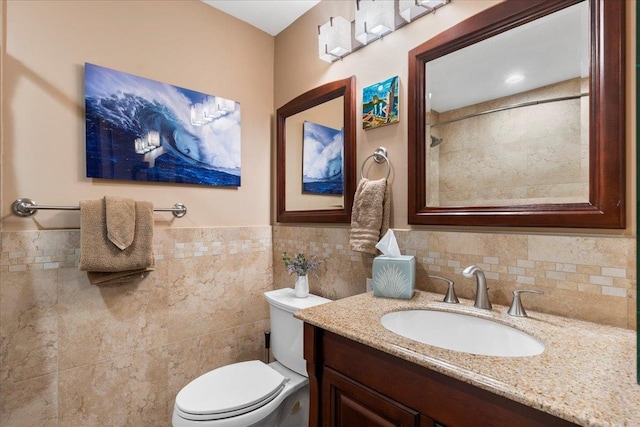 bathroom with toilet, walk in shower, vanity, and tile walls