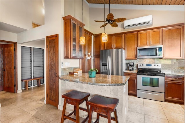 kitchen featuring appliances with stainless steel finishes, a breakfast bar, an AC wall unit, and light stone counters