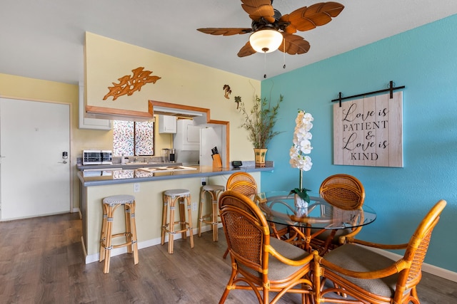 dining area featuring wood-type flooring and ceiling fan