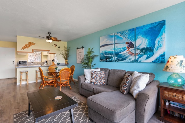 living room with wood-type flooring and ceiling fan