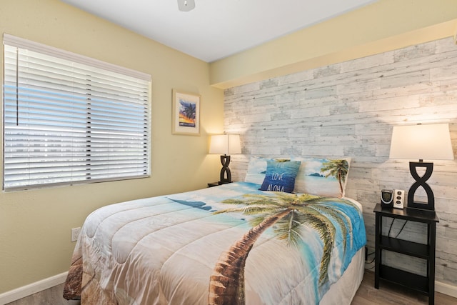 bedroom with wooden walls and wood-type flooring