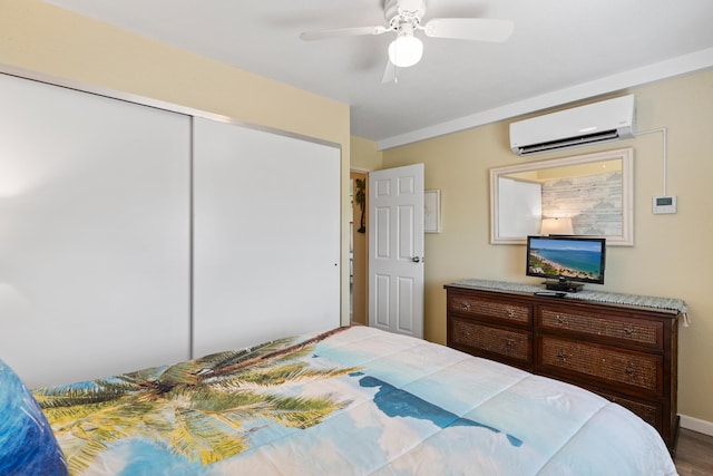 bedroom featuring a closet, ceiling fan, hardwood / wood-style flooring, and a wall mounted air conditioner