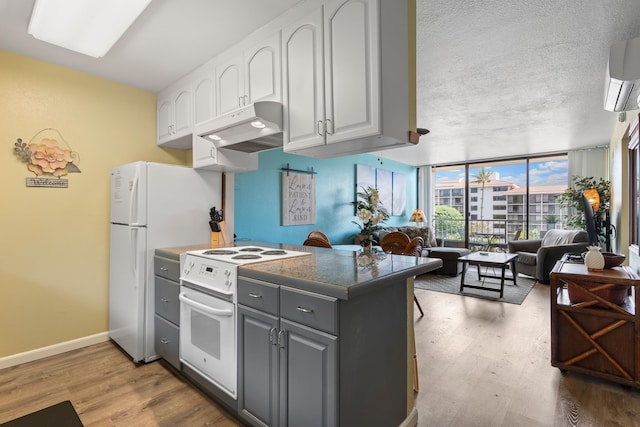 kitchen featuring white cabinets, gray cabinets, hardwood / wood-style floors, electric range, and a wall of windows