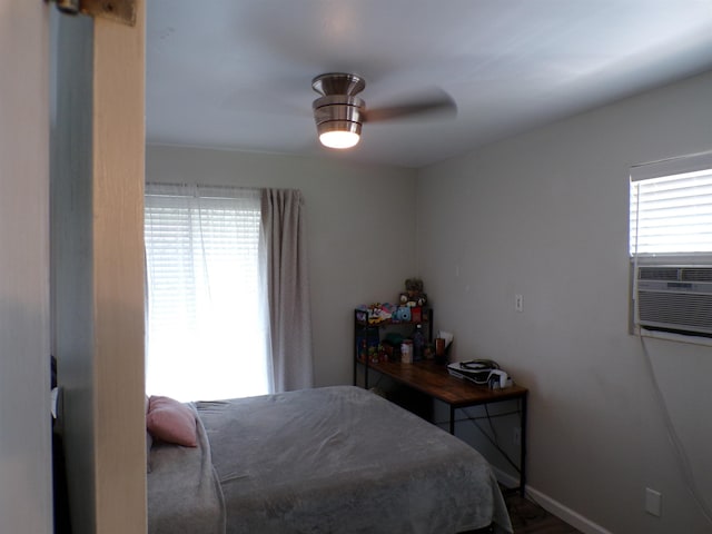 bedroom with ceiling fan, cooling unit, and multiple windows