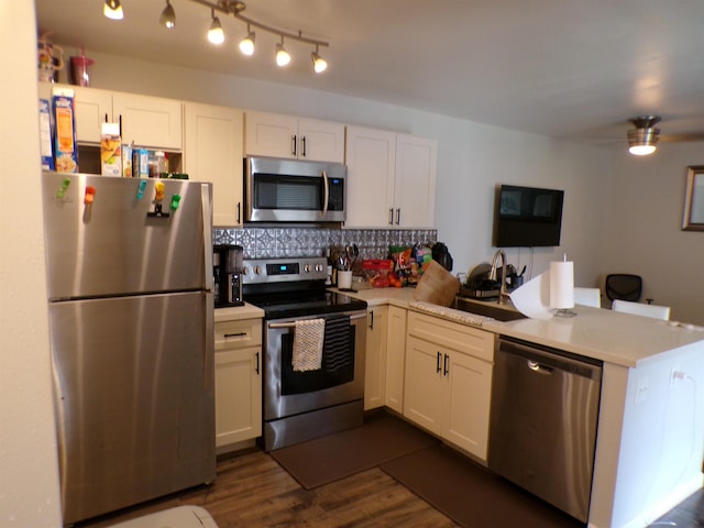 kitchen with sink, stainless steel appliances, white cabinets, and kitchen peninsula