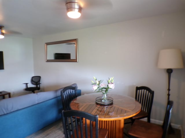 dining space with hardwood / wood-style floors and ceiling fan