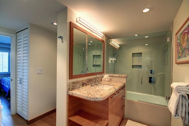 bathroom featuring combined bath / shower with glass door, vanity, and wood-type flooring