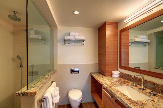 bathroom featuring tile walls, toilet, an enclosed shower, and vanity with extensive cabinet space