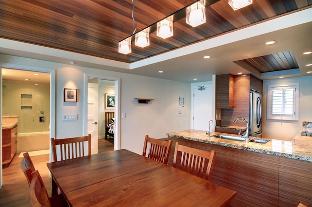 dining room featuring dark hardwood / wood-style flooring, sink, wood ceiling, and a raised ceiling