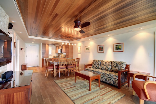 living room featuring a raised ceiling, dark hardwood / wood-style flooring, wooden ceiling, and ceiling fan