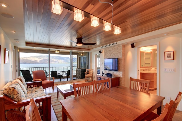 dining area featuring wood ceiling, a water and mountain view, and light hardwood / wood-style flooring