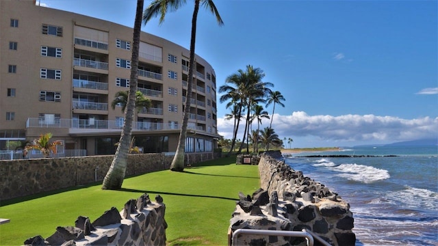 view of property's community with a water view and a lawn