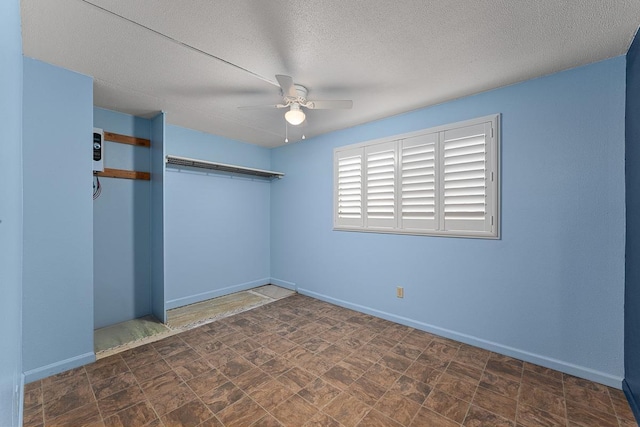 2747 S Kihei Rd Unit D102, Kihei, HI 96753 - unfurnished bedroom with baseboards, a textured ceiling, a closet, and a ceiling fan