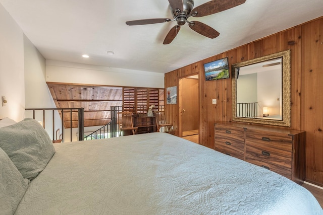 bedroom with wooden walls and ceiling fan