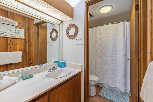 bathroom with tile floors, vanity with extensive cabinet space, and toilet