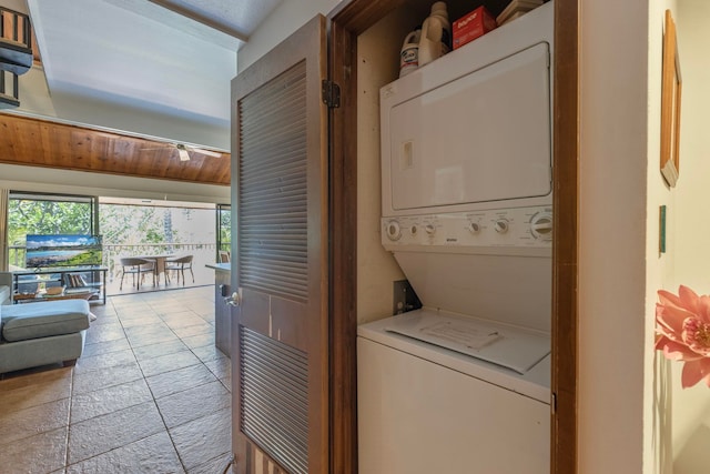 laundry area featuring stacked washing maching and dryer and light tile flooring