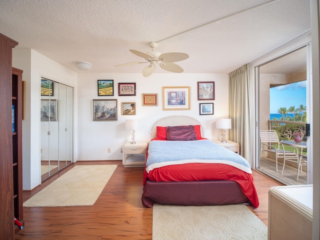 bedroom with wood-type flooring, a textured ceiling, and ceiling fan