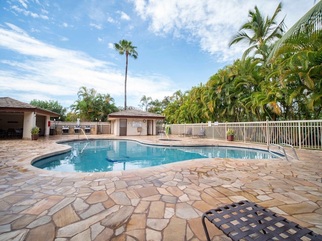 view of swimming pool featuring a patio area and an outbuilding