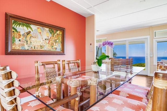 dining area featuring a water view and wood finished floors