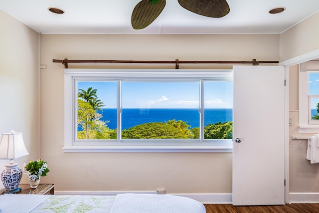 unfurnished bedroom with dark wood-style floors, a water view, and baseboards