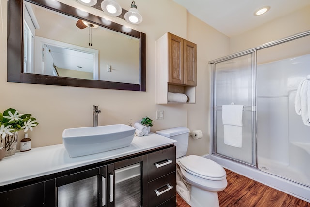 full bath featuring toilet, a stall shower, wood finished floors, and vanity