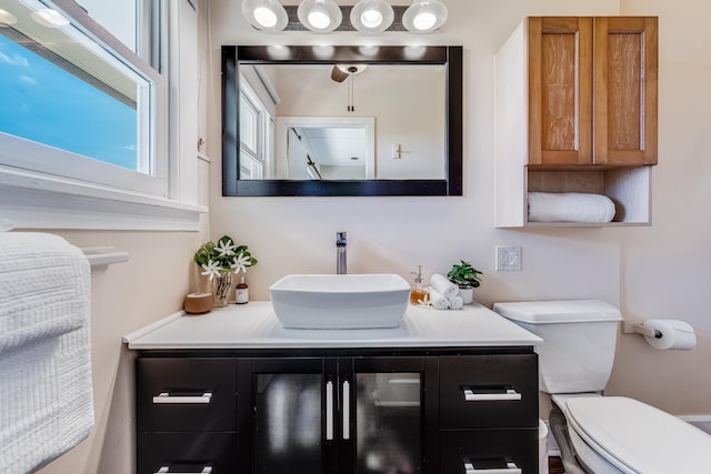 bathroom with plenty of natural light, vanity, and toilet