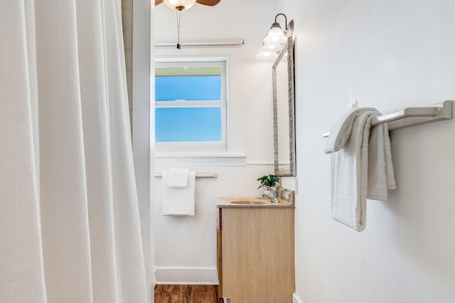 bathroom with wood finished floors, vanity, and baseboards