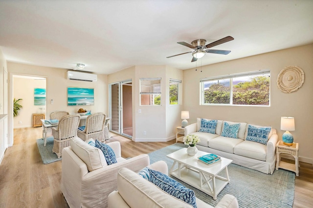 living room with light hardwood / wood-style flooring, a wall mounted AC, and ceiling fan