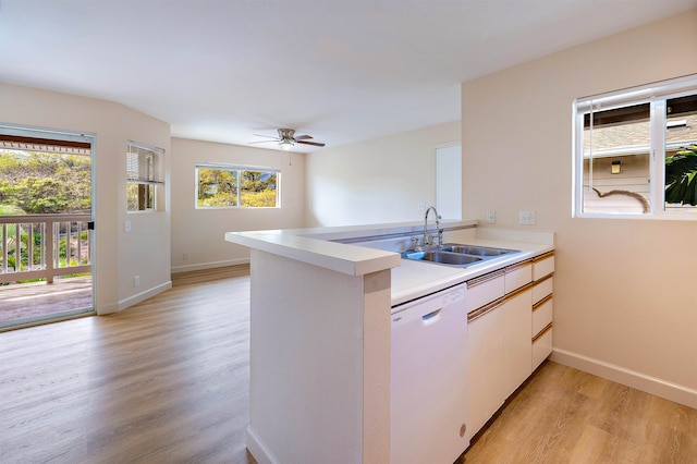 kitchen with kitchen peninsula, dishwasher, and plenty of natural light