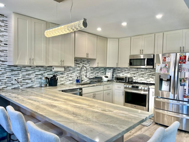 kitchen with a breakfast bar, sink, kitchen peninsula, and stainless steel appliances