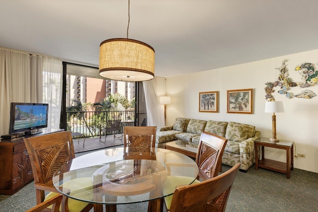 dining area featuring carpet flooring and a wall of windows