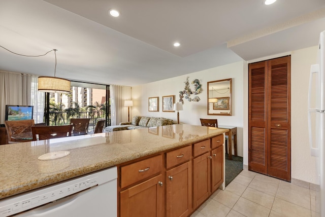 kitchen featuring open floor plan, dishwasher, light stone counters, light tile patterned floors, and recessed lighting