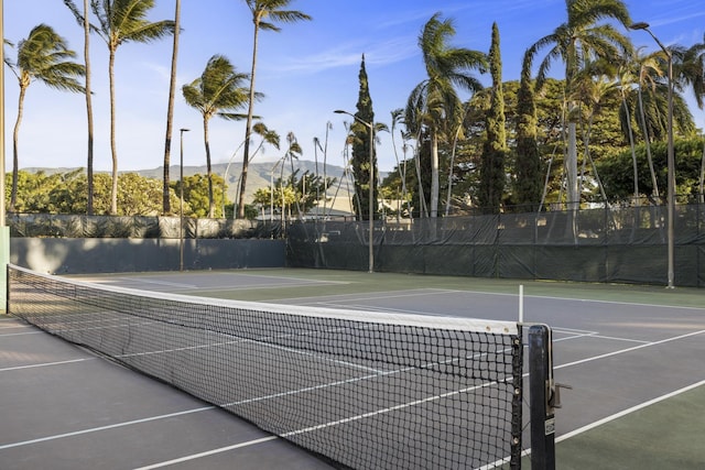 view of sport court featuring fence and a mountain view