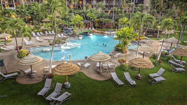 community pool with a patio and a lawn