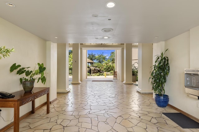 interior space with stone tile floors, recessed lighting, and baseboards