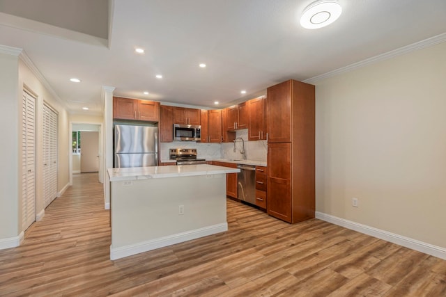 kitchen with sink, crown molding, light hardwood / wood-style floors, a kitchen island, and stainless steel appliances