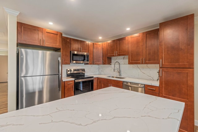 kitchen featuring light stone countertops, appliances with stainless steel finishes, tasteful backsplash, and sink