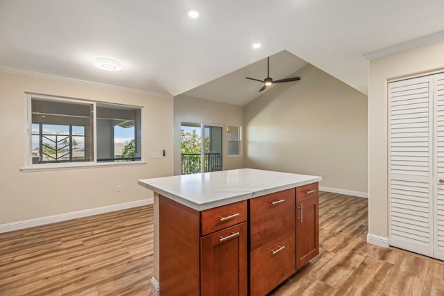 kitchen featuring ornamental molding, ceiling fan, light hardwood / wood-style flooring, a kitchen island, and lofted ceiling