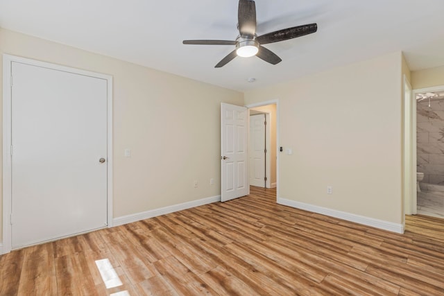 unfurnished bedroom featuring light wood-type flooring, ensuite bath, and ceiling fan